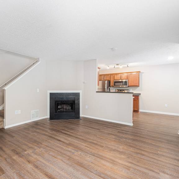 a living room with a fireplace and wooden floors