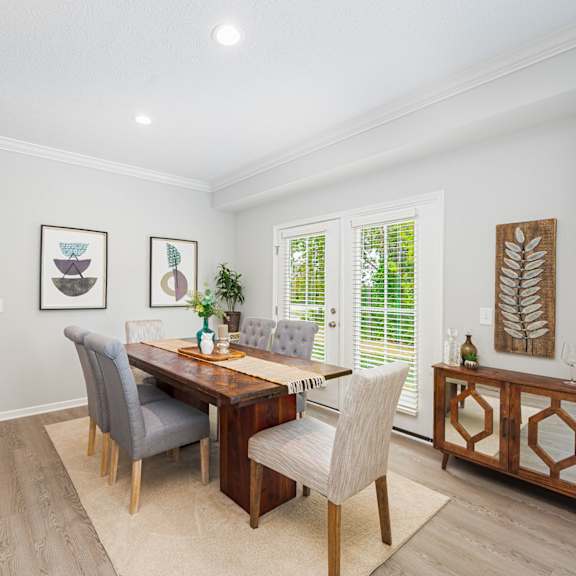 a dining room with a wooden table and chairs
