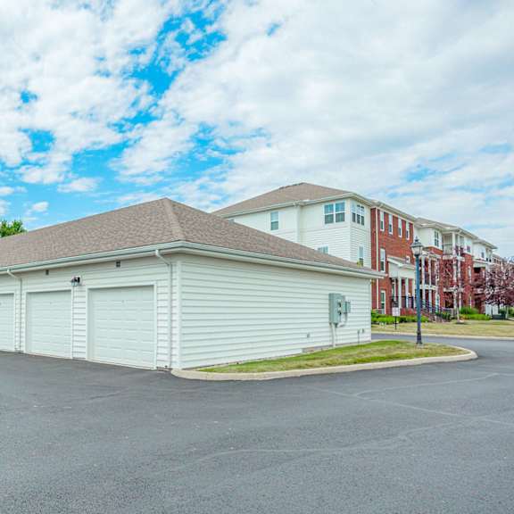 a garage with white doors and a building in the background