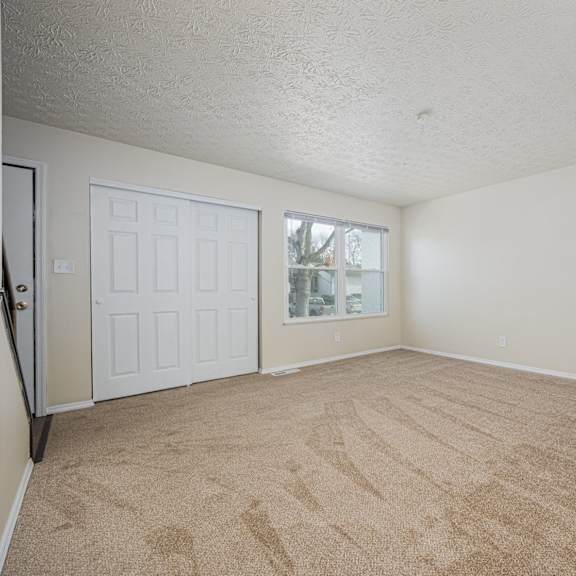 a room with a carpeted floor and a white door.