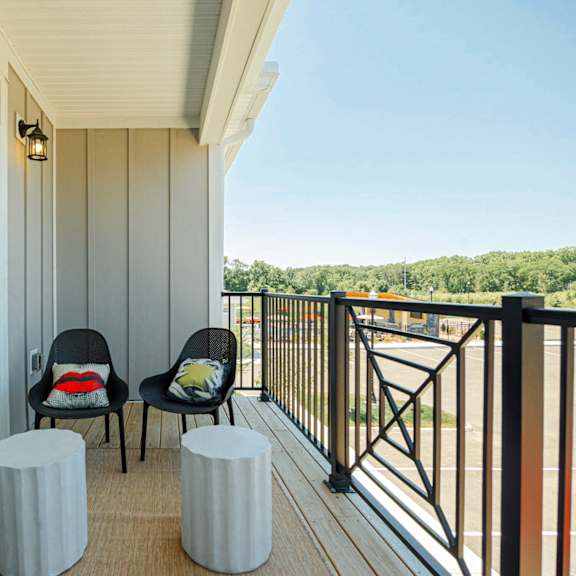 a balcony with two chairs and a view of a river