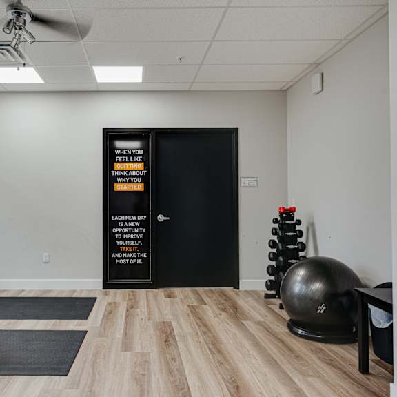 a fitness room with a yoga ball and chair and a door to the gym