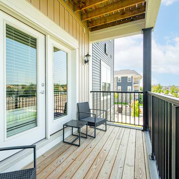 a balcony with two chairs and a wooden deck