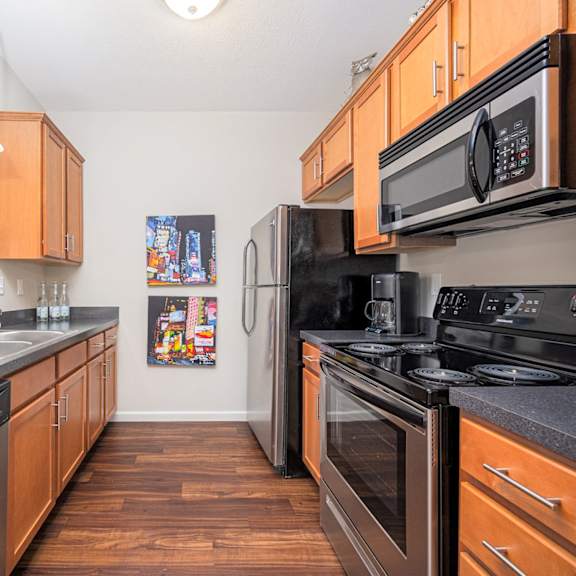 a kitchen with black appliances and wooden cabinets.
