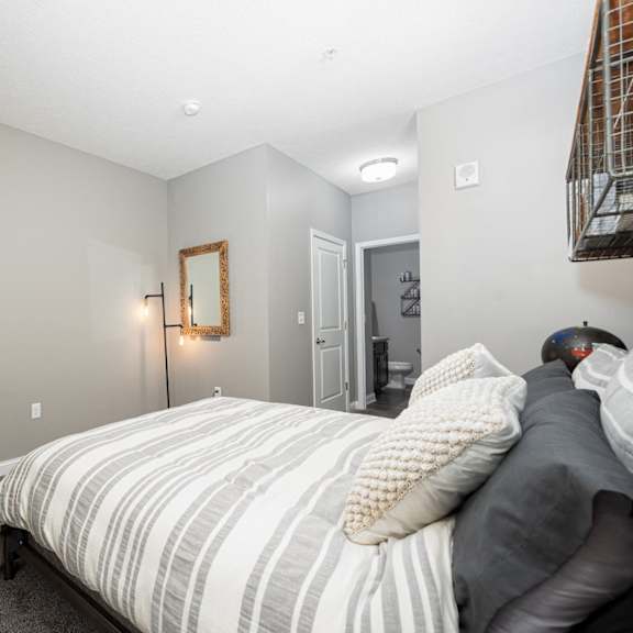 a bedroom with a bed and a dresser and a bathroom