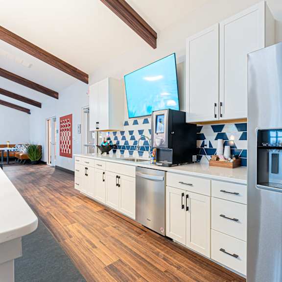 a modern kitchen with a refrigerator on the right.