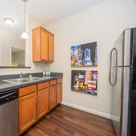 a kitchen with wooden cabinets and a black fridge.