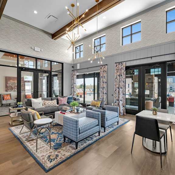 a modern living room with a blue rug and a dining table.