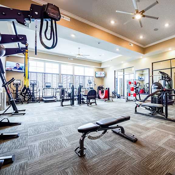 a gym with a lot of equipment and a large window