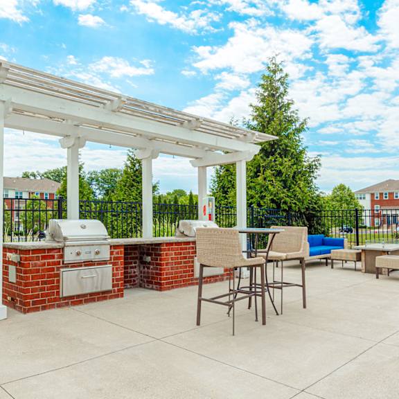 a patio with a barbecue grill and a pergola