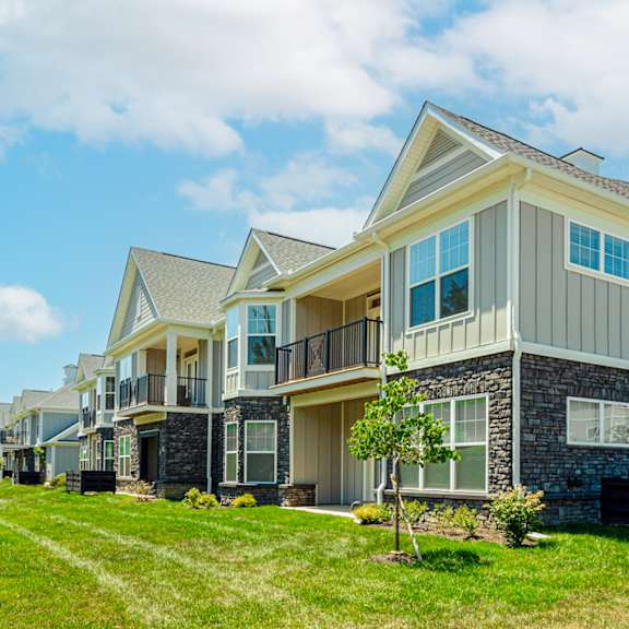 a row of houses with grass and trees in front of them