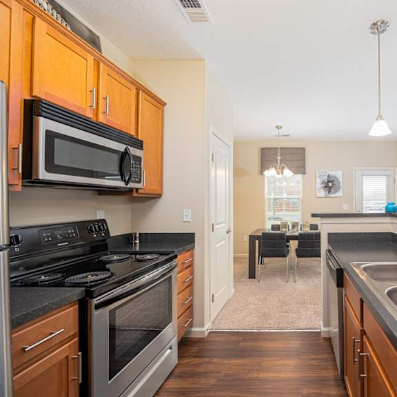 a kitchen with wooden cabinets and black countertops.