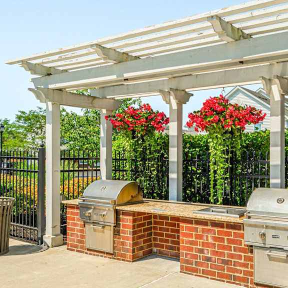 a patio with a barbecue grill and a pergola