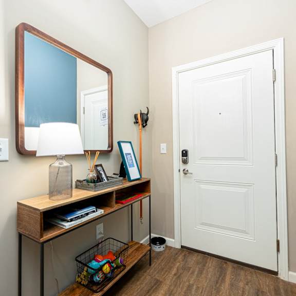 a hallway with a mirror and a desk with a door