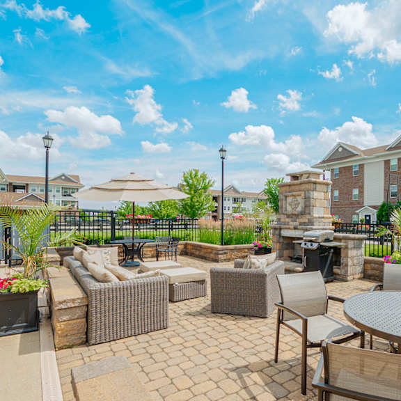 an outdoor patio with tables and chairs and a building in the background