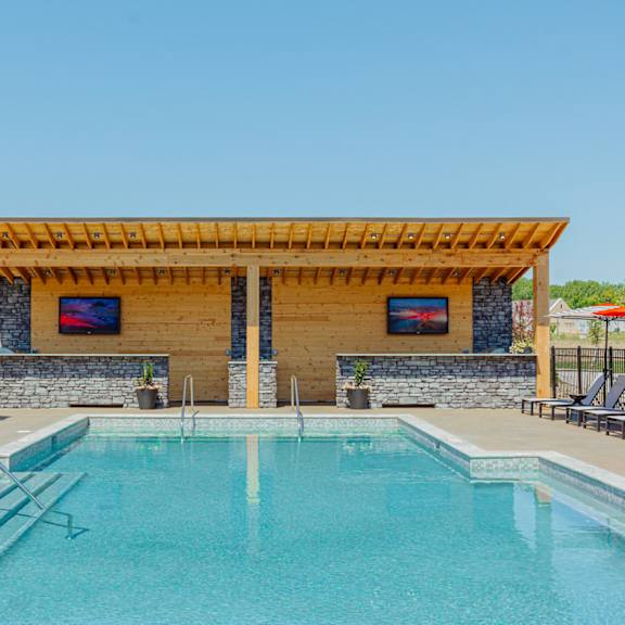 a swimming pool with a pergola next to a resort style pool