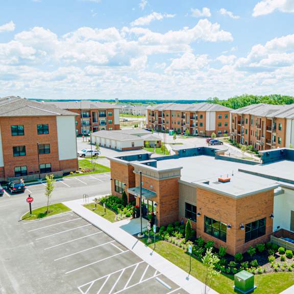an aerial view of an apartment complex with a parking lot