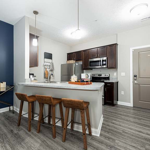 a kitchen with a large island with three stools