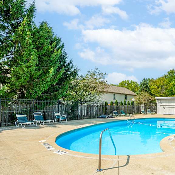 our apartments have a resort style pool with chairs and a fence