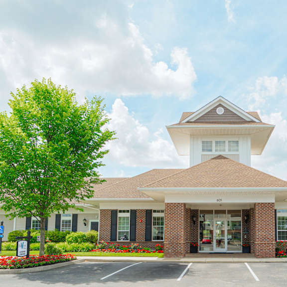 the exterior of a building with a parking lot and trees