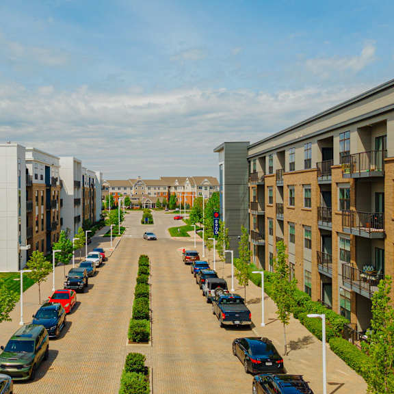 an aerial view of a street with cars parked in front of buildings