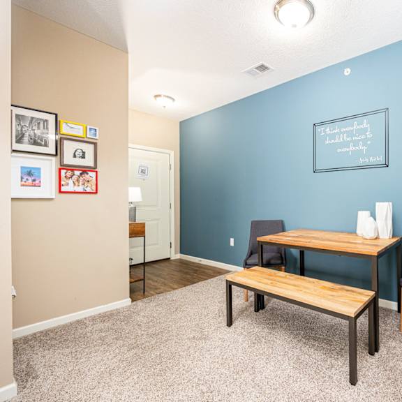 a home office with a blue wall and a desk with a chair and a table