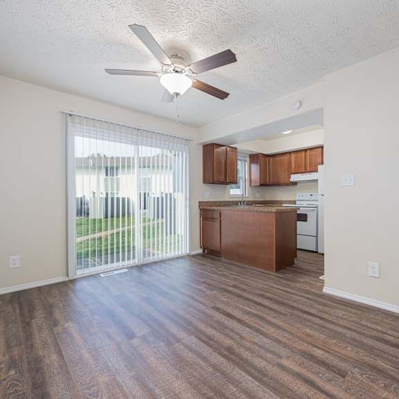 a room with a ceiling fan and wooden flooring.