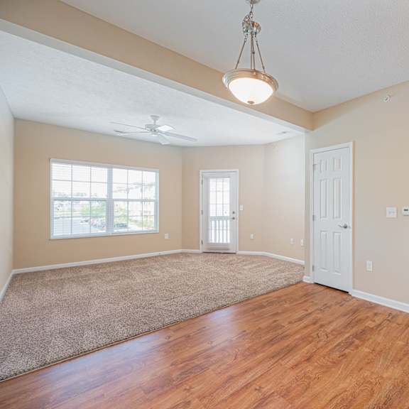 an empty living room and dining room with hard wood flooring