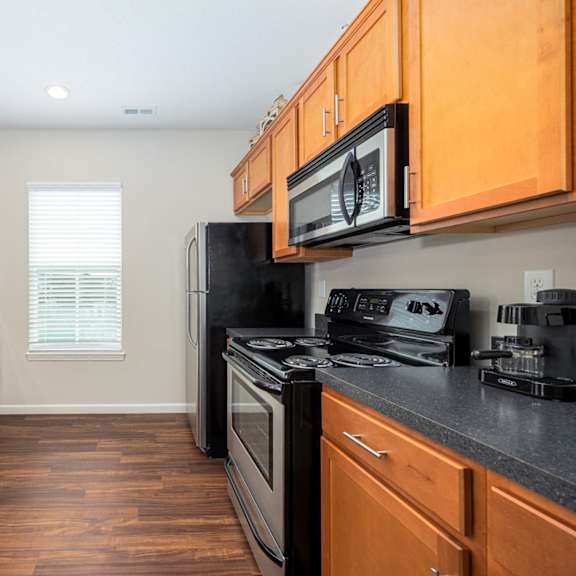 a kitchen with wooden cabinets and black appliances.