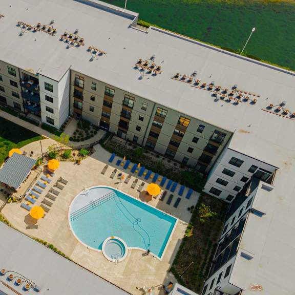an aerial view of an apartment building with a swimming pool and a courtyard