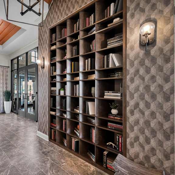 a large bookshelf filled with books in a room with a wooden ceiling.