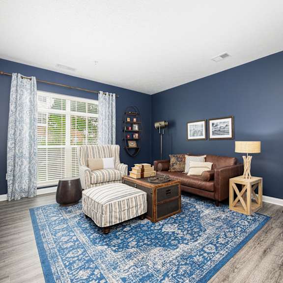 a living room with blue walls and a brown couch and chair