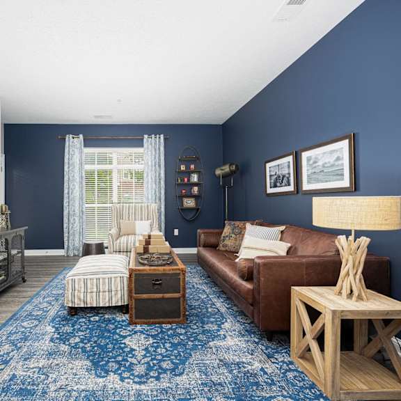 a living room with blue walls and a brown couch and a blue rug