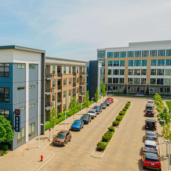 an aerial view of an apartment complex with cars parked in a parking lot
