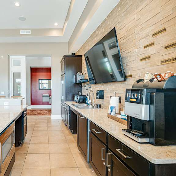 a large kitchen with a coffee machine and a television