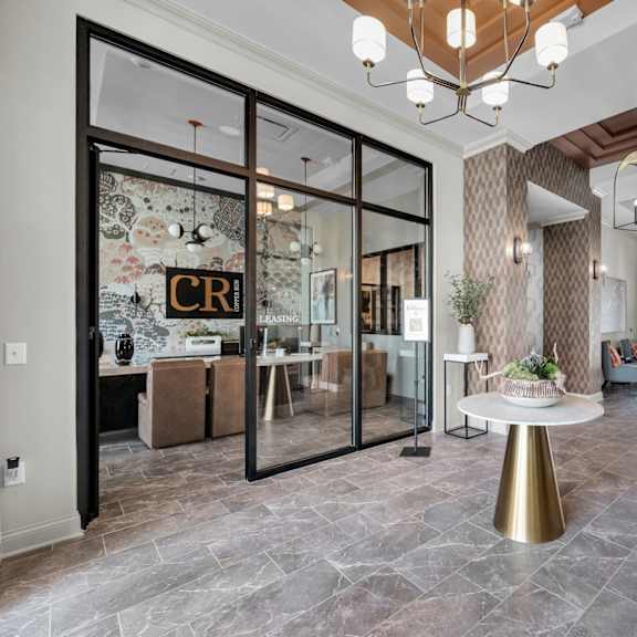 a modern interior with a glass door entrance and a round table in the center.