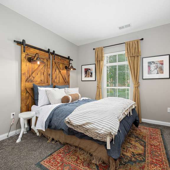 a bedroom with a bed and a window with a barn door