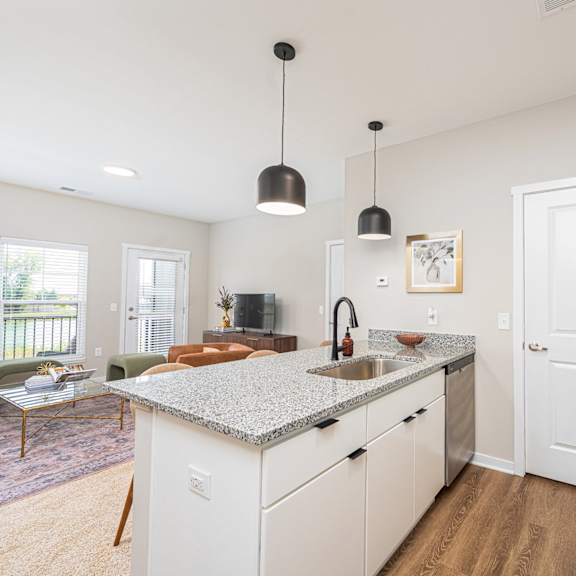 a kitchen with a counter top and a door to a living room