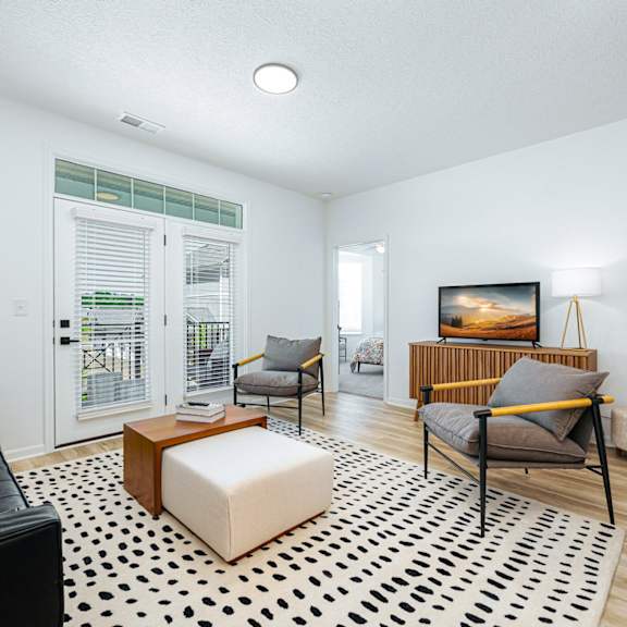 a living room with a couch and a chair and a television