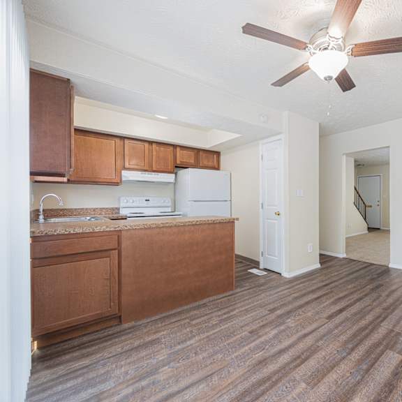 a room with a brown floor and a ceiling fan.