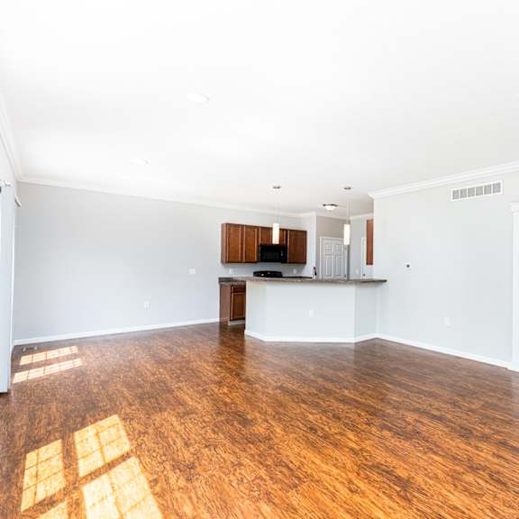 a large empty room with wooden floors and white walls.
