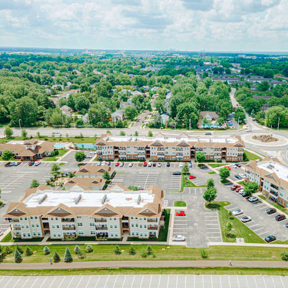 an aerial view of an apartment complex and parking lot
