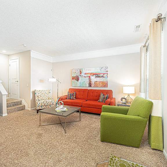 a living room with a red couch and a green chair