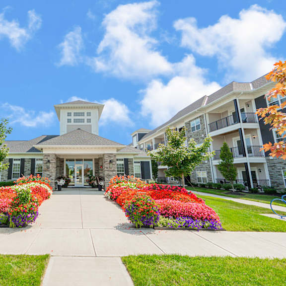 a building with a sidewalk and colorful flowers in front of it