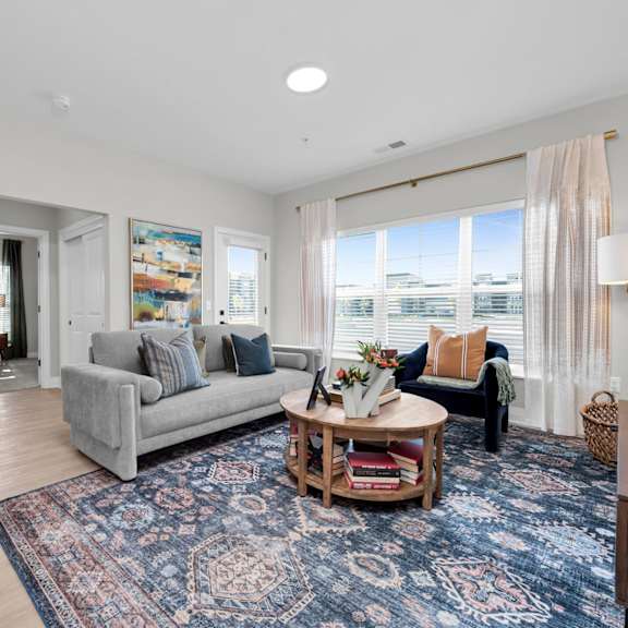 a living room with a grey couch and a round coffee table.