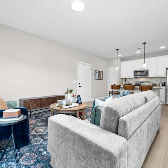 a living room with a grey couch and a blue chair.