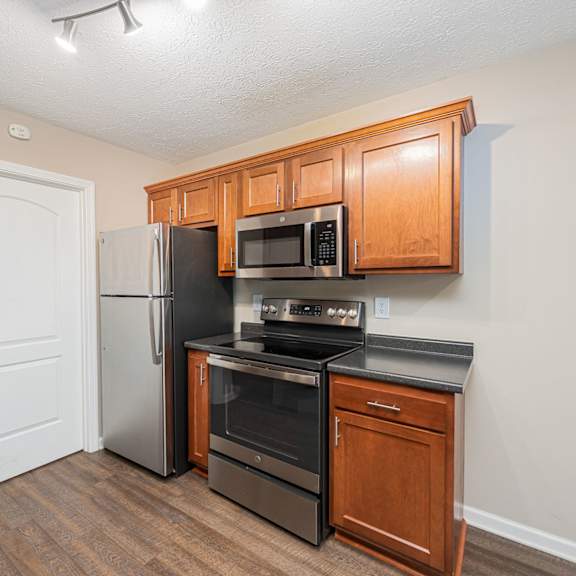 a kitchen with black appliances and wooden cabinets and a refrigerator