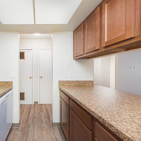 a kitchen with granite counter tops and wooden cabinets