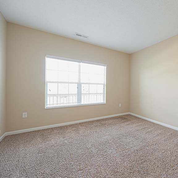 an empty room with carpet and a window