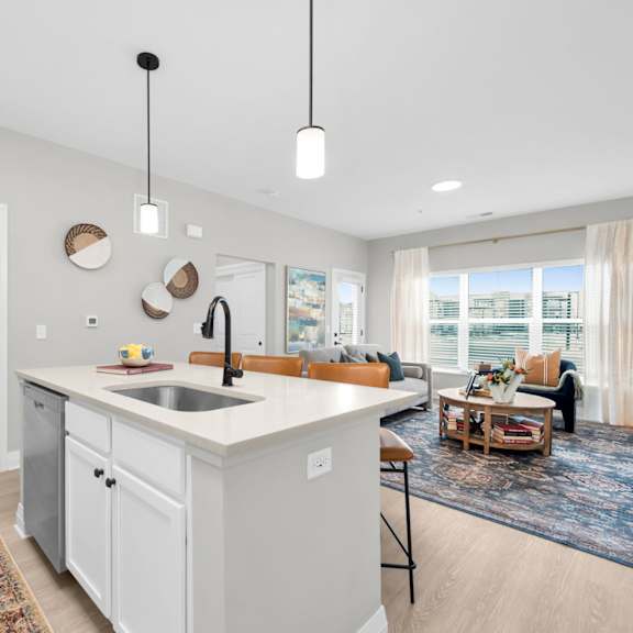 a modern kitchen with a white island and a rug on the floor.